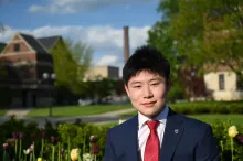 person in suit standing in front of flowers